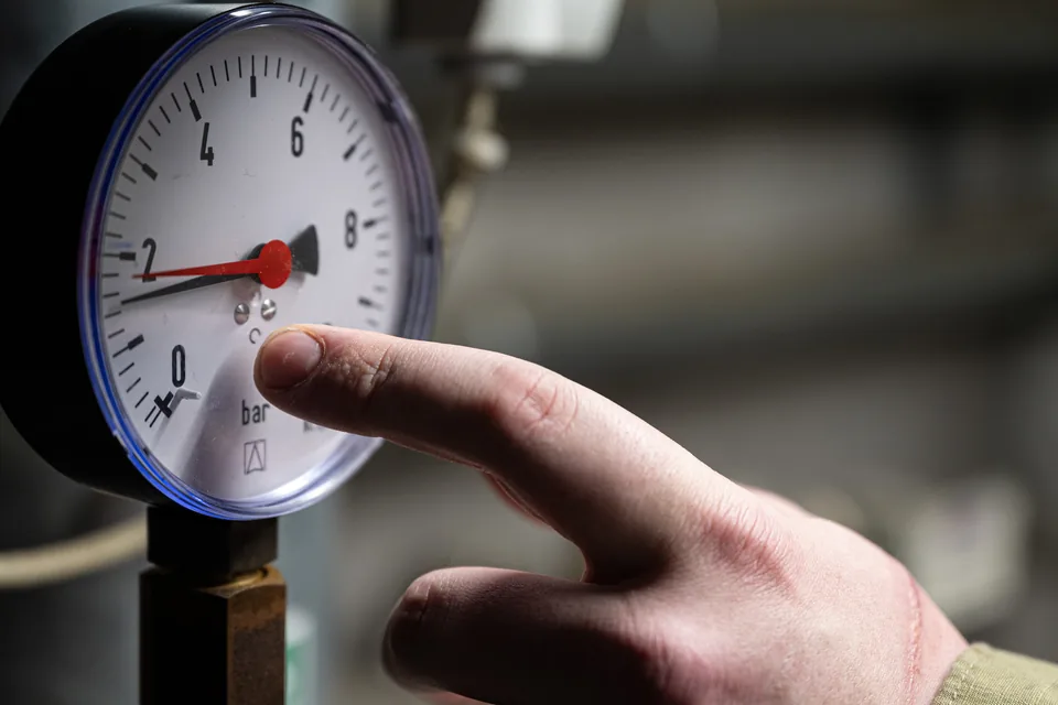 Doigt d'un technicien pointant l'aiguille d'un manomètre de contrôle